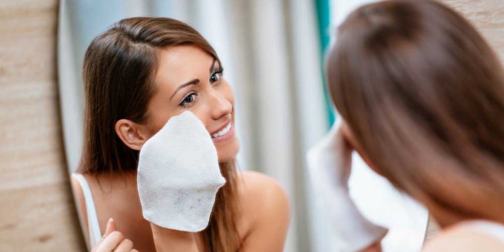 woman removes makeup with napkin