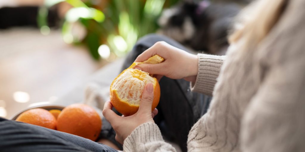woman is peeling orange