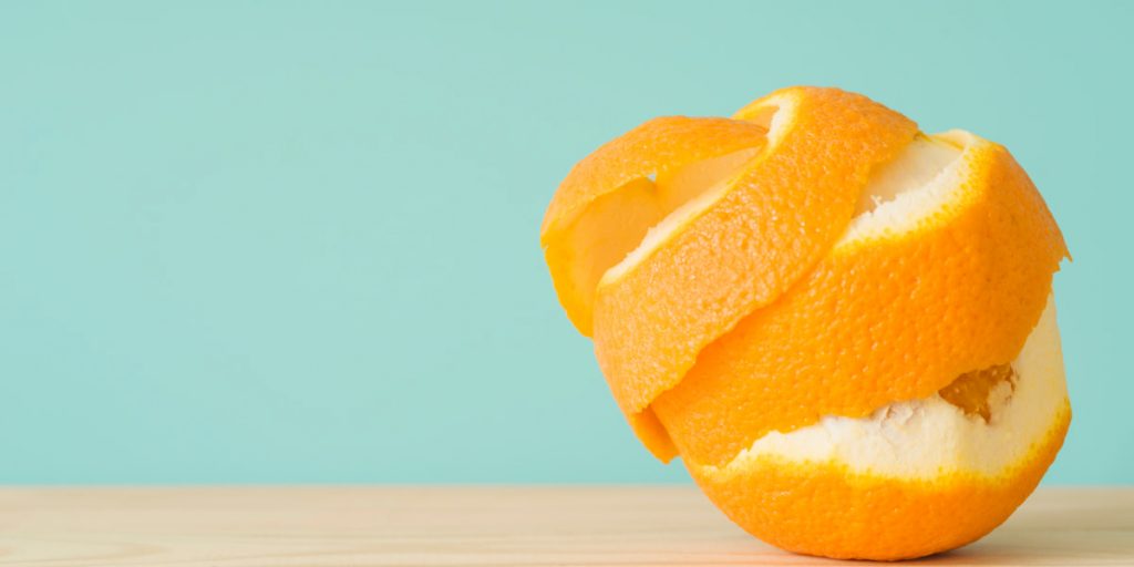 peeled orange on light blue background