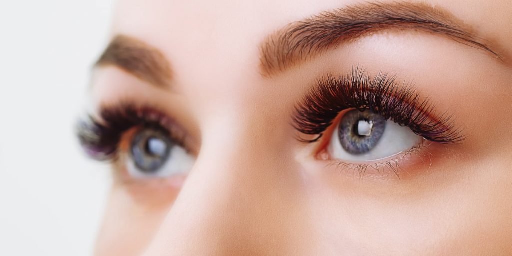blue-eyed woman with eyelash extensions closeup