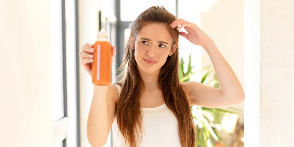 woman is looking at orange juice jar