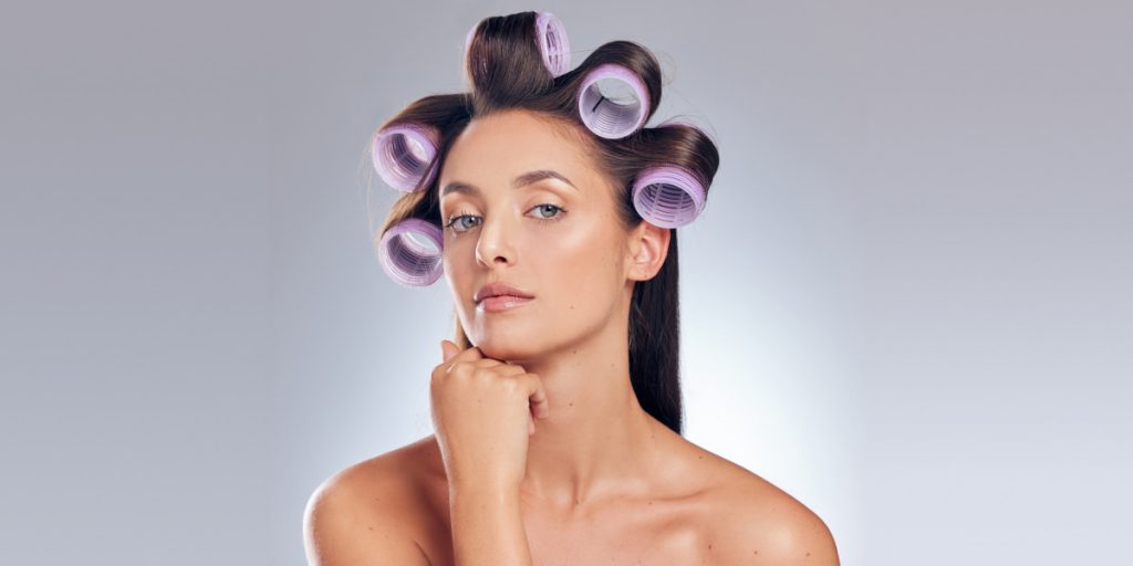 woman with hair rollers looking at the camera