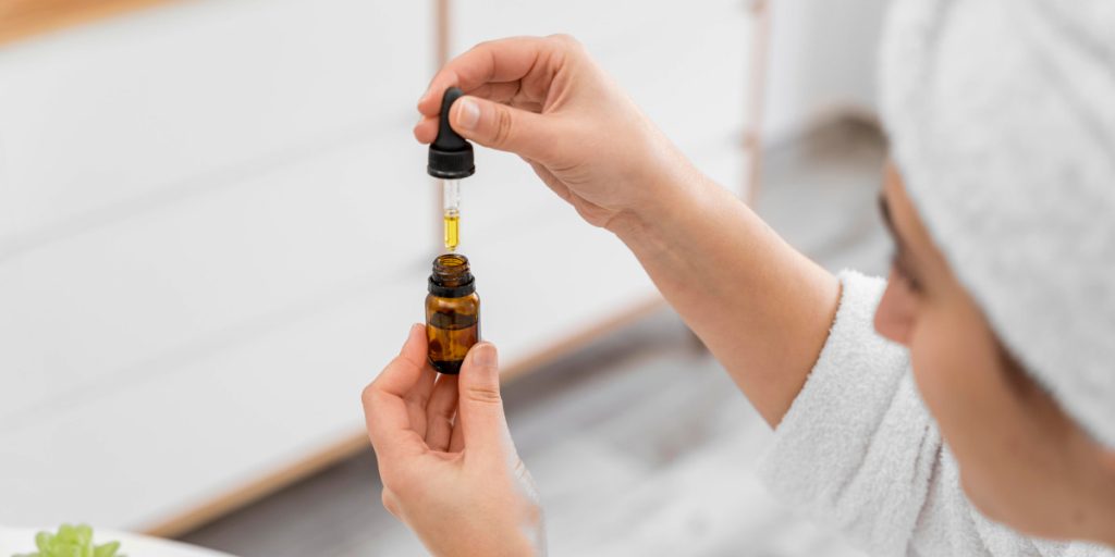 a woman is holding vial with dry oil