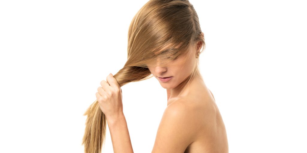 blonde is pulling her hair on white background