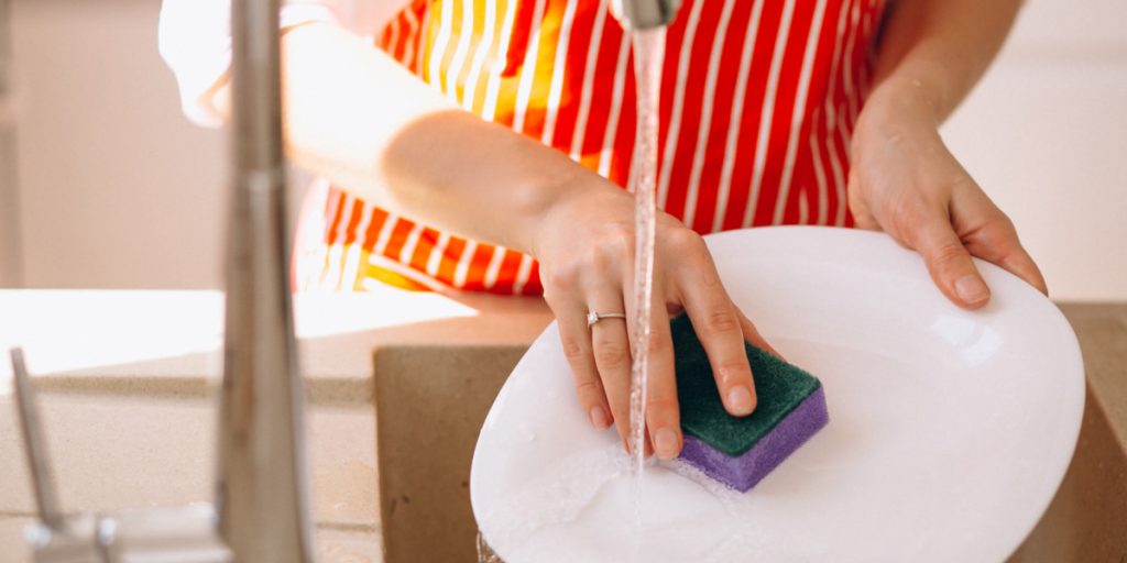washing white dish with sponge