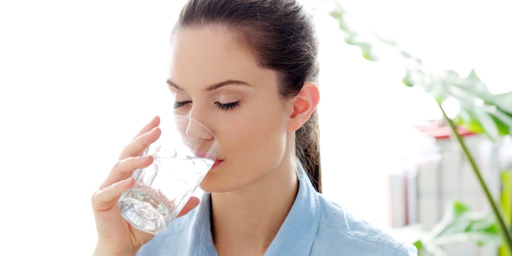 girl is drinking water with closed eyes