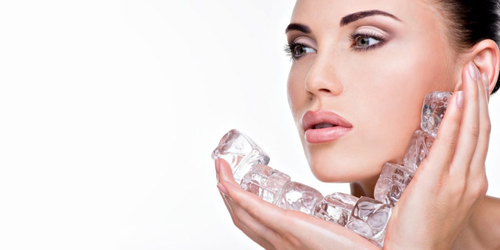 girl is holding ice in her hands on white background