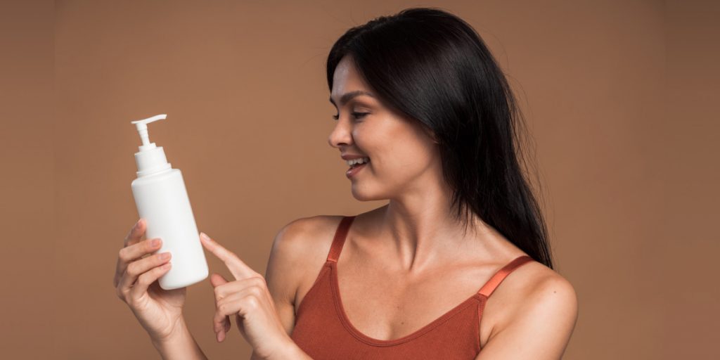 girl is holding white shampoo bottle