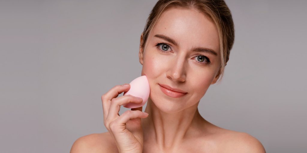 woman is using makeup sponge