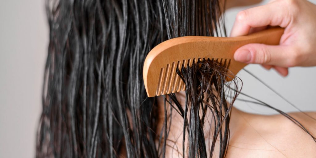 girl is combing her wet hair