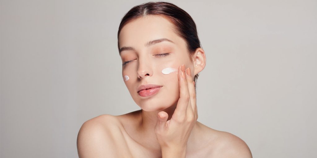 woman applyies a cream on the face