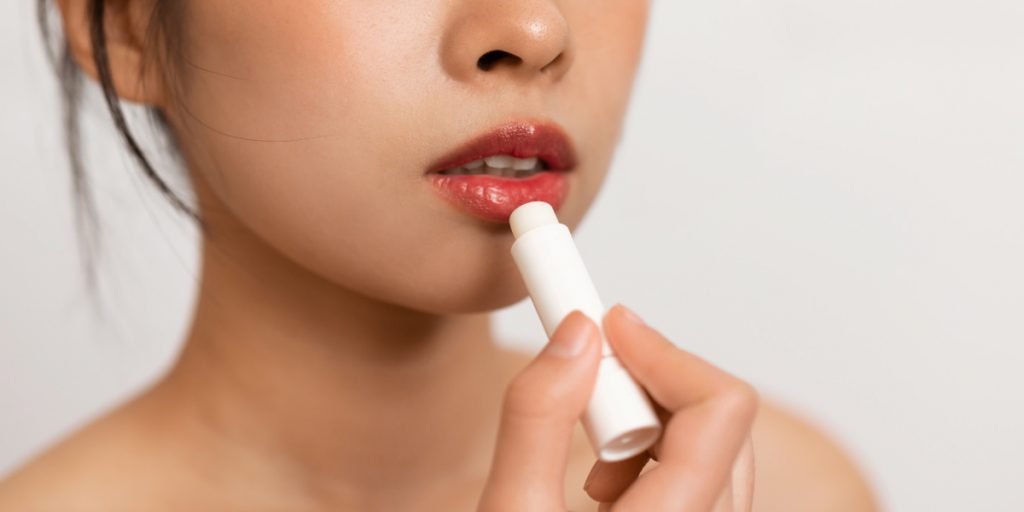 woman applies a lipstick on her lips