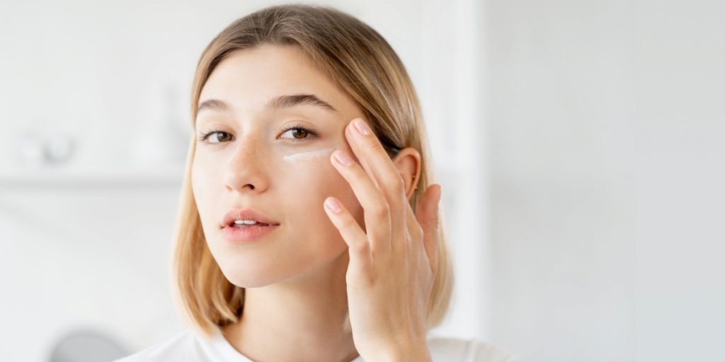 woman applying moisturizing cream on the face